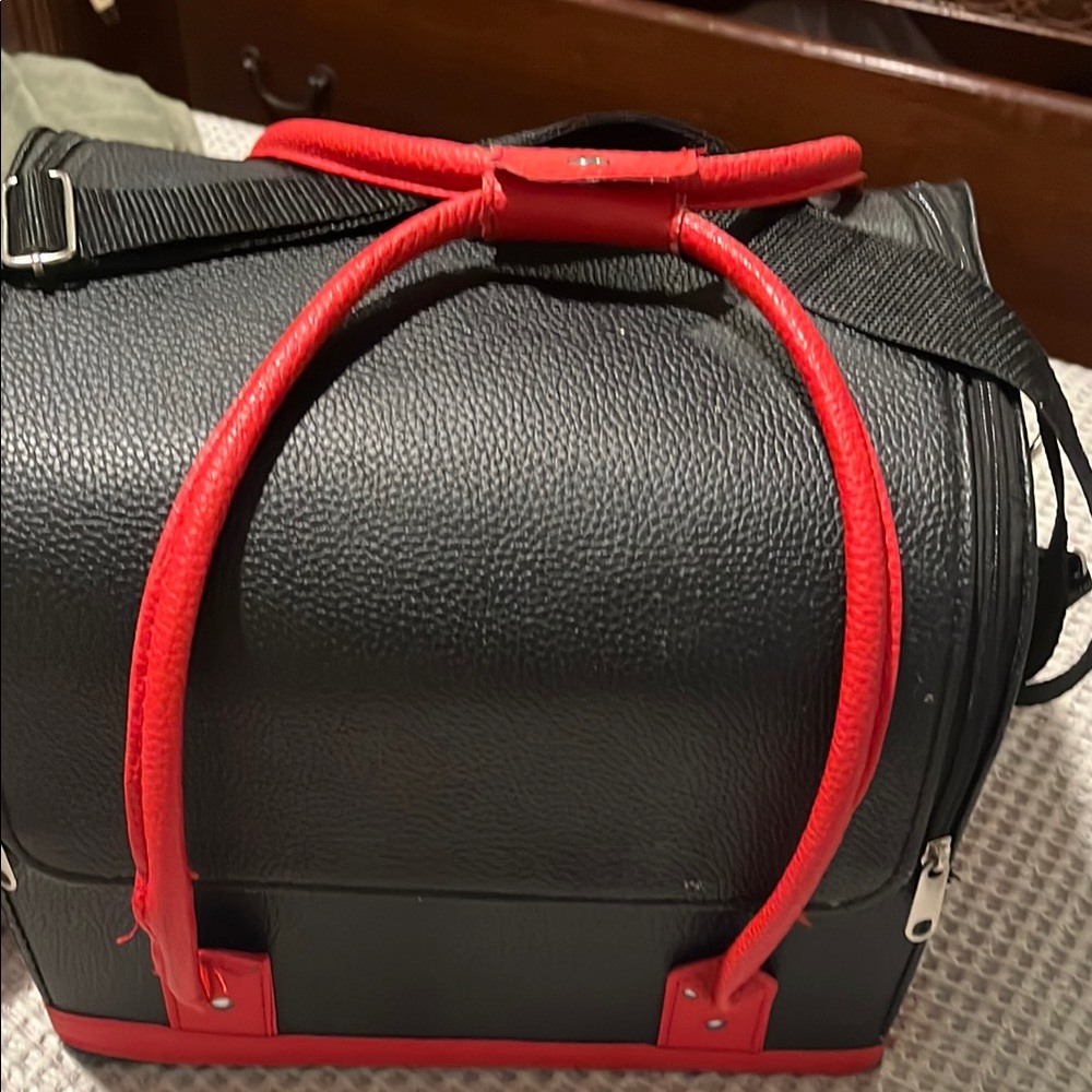 Black makeup train with red straps